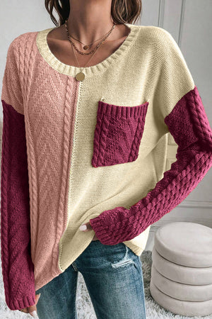 Colorblock cable knit sweater with crew neck and chest pocket in red-violet and cream acrylic.
