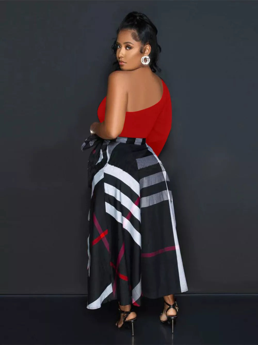 Red one-shoulder midi dress with a black plaid belted skirt.
