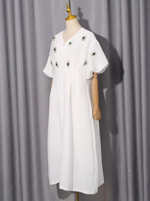 White midi dress with V-neck, puff sleeves, and scattered green rhinestone embellishments.