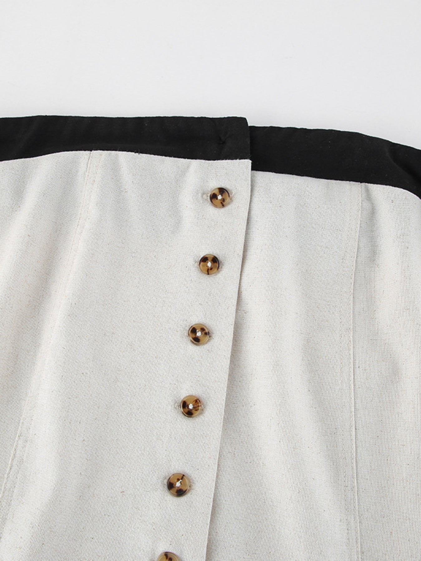 Button front tube maxi dress in beige cotton blend with tortoiseshell buttons and black trim.