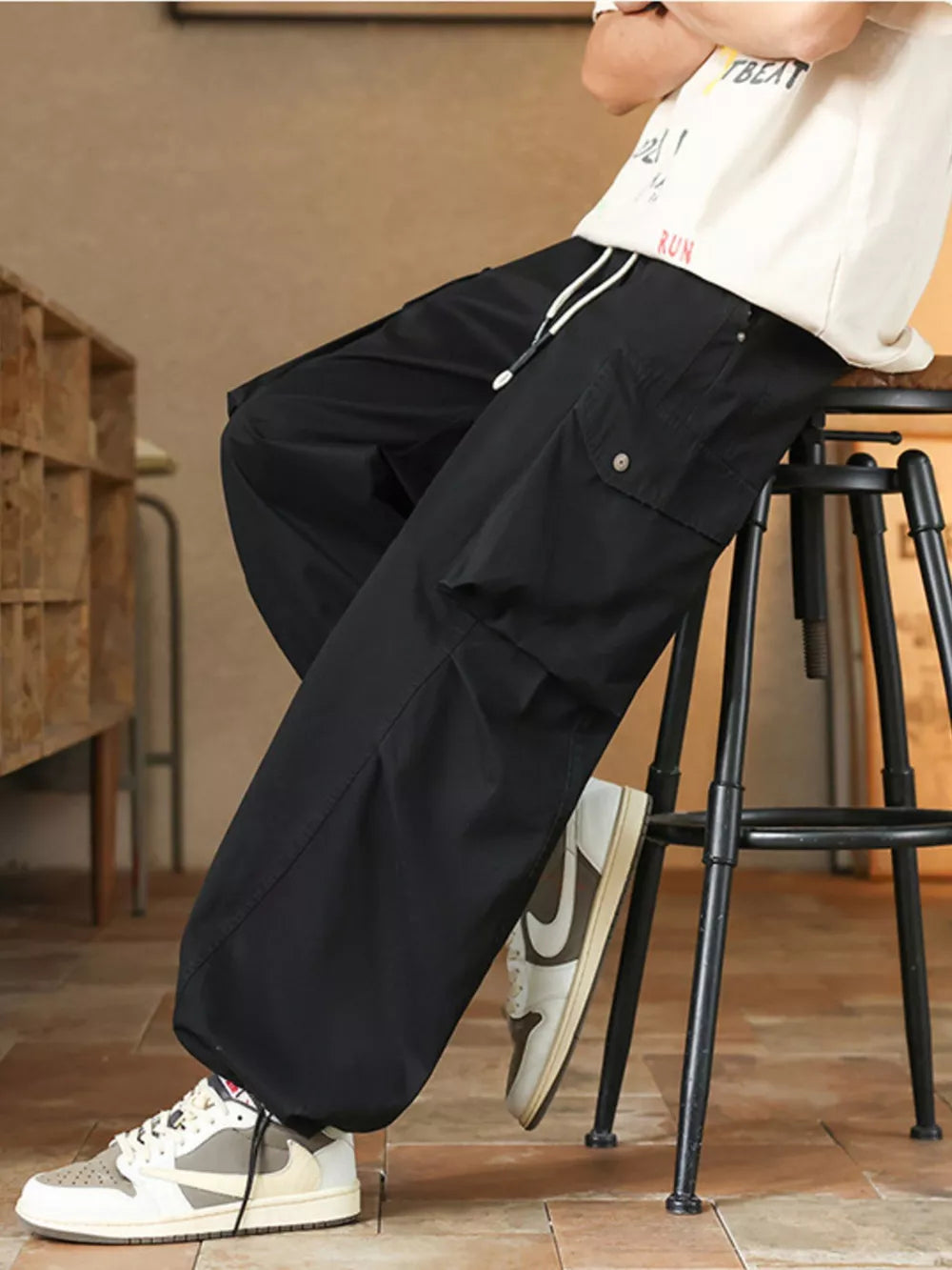 Black cargo pants with drawstring waist and button-flap pockets