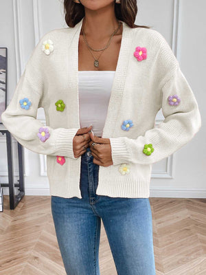 White knit cardigan with embroidered multicolor flowers, open front, long sleeves.