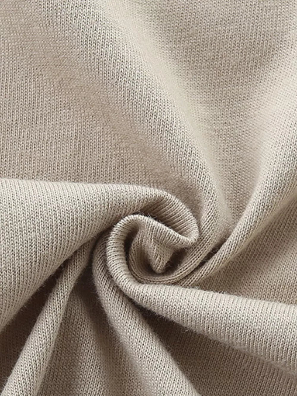 Close-up of beige cotton knit fabric with soft texture.