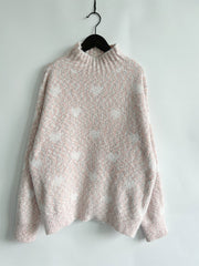 Blush pink acrylic turtleneck sweater with a subtle heart motif pattern.