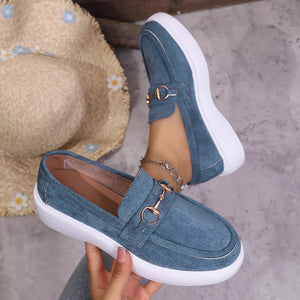 Blue suede loafers with gold horse-bit detail and white sole.