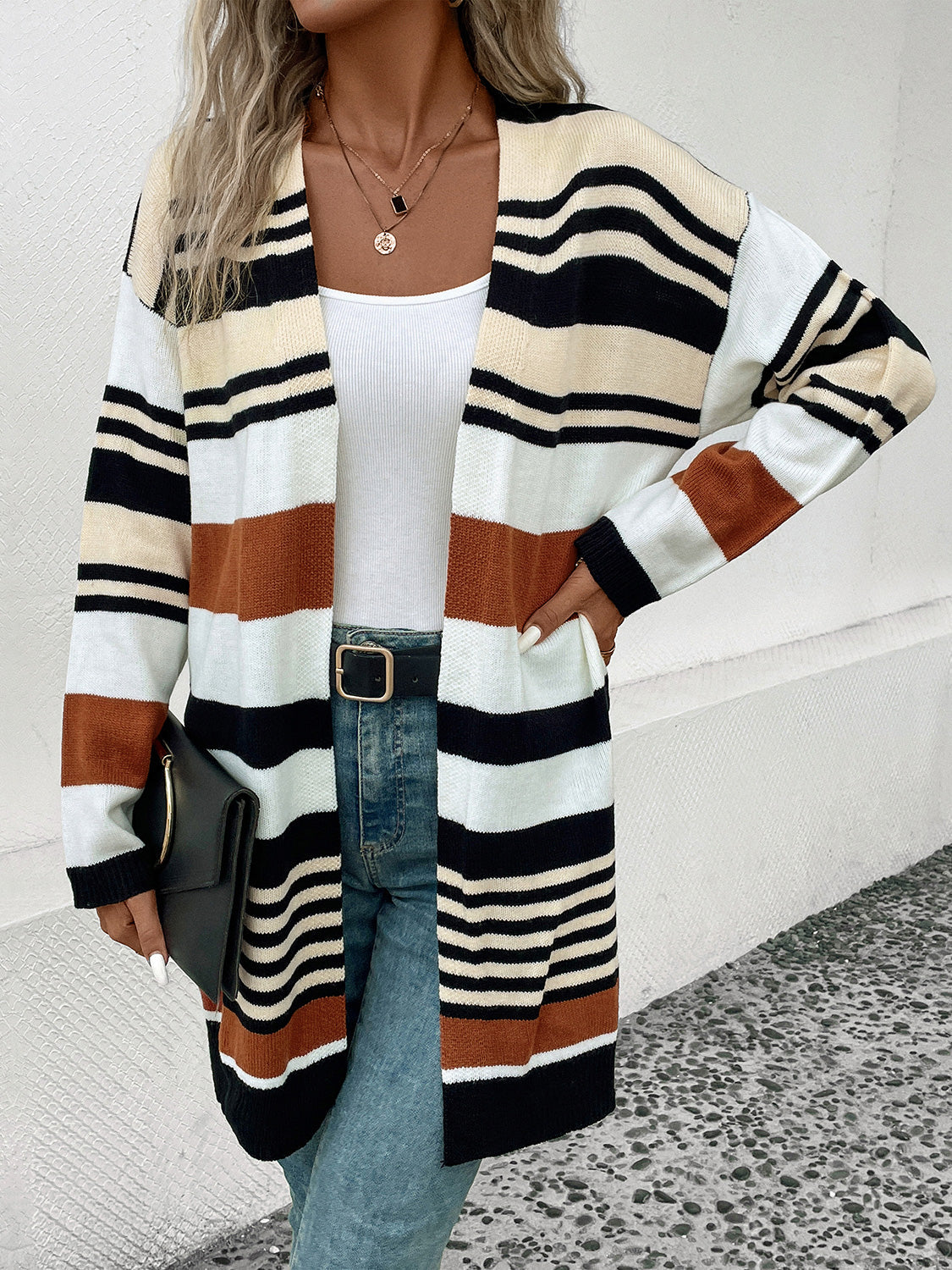 Bold stripe knit duster cardigan with black, white, beige, and burnt orange stripes.