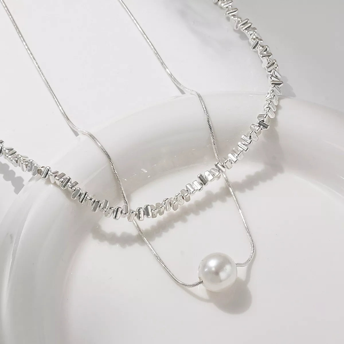 Elegant double layered silver necklace with pearl accent and textured beads