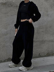 Black velour cropped zip hoodie and wide leg pants set with a black crop top.