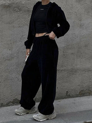 Black velour cropped zip hoodie and wide leg pants set with a black crop top.
