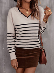 Beige knit sweater with black stripes, V-neck, and scalloped trim.