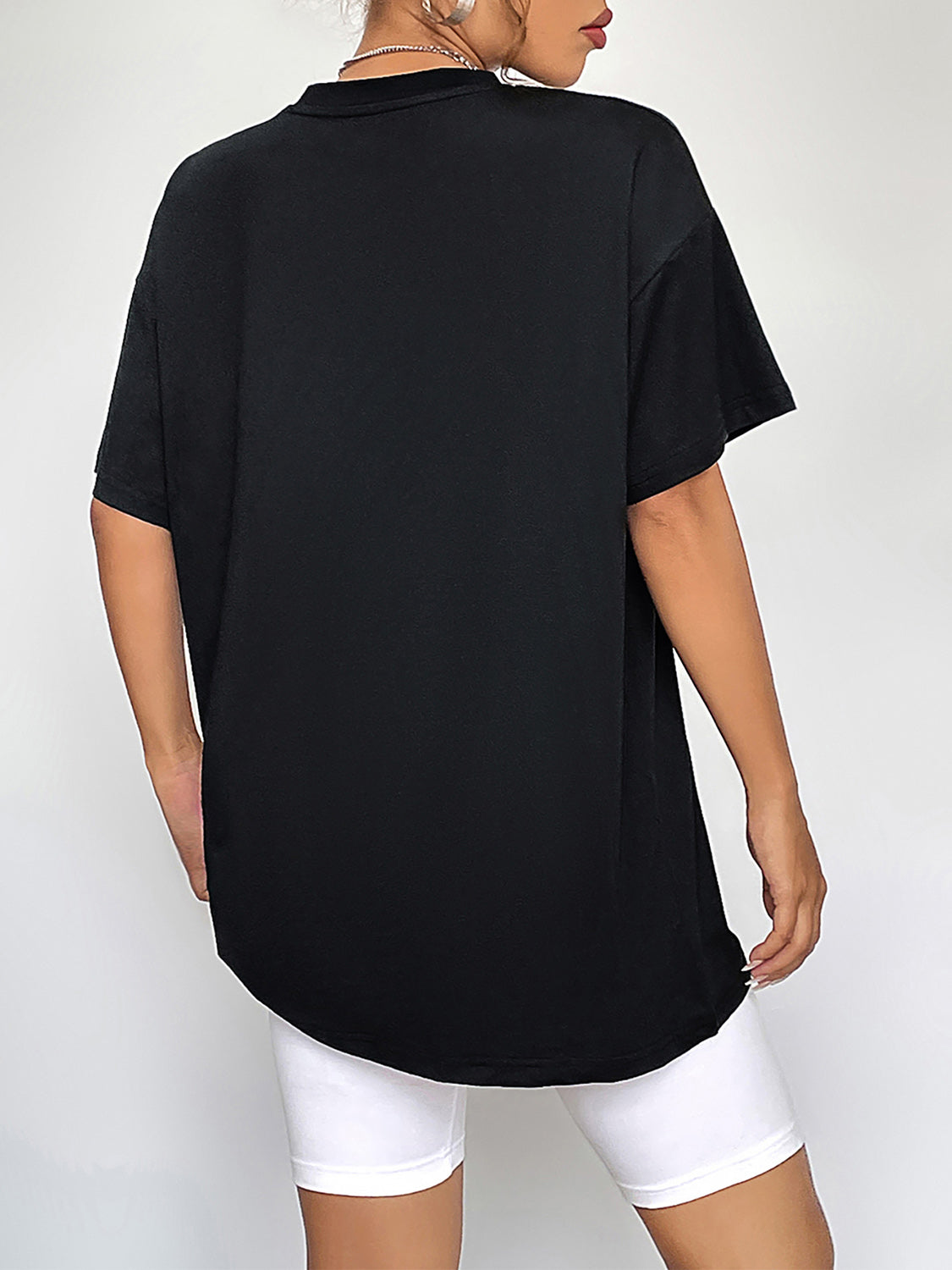Black oversized t-shirt with short sleeves and a crew neck, shown from the back.