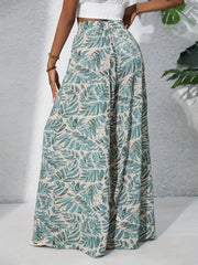 Palazzo trousers in green tropical leaf print, 100% polyester, with a high elastic waist.