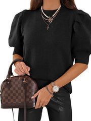 Black knit sweater with mock neck and puff sleeves.