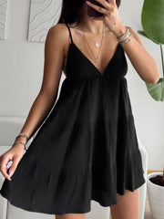 Black cotton tiered mini dress with a V-neck and ruffled hem.