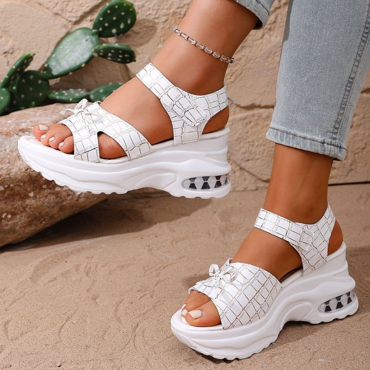 White textured open-toe wedge sandals with adjustable straps and air cushioning detail.