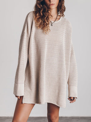 Beige oversized open-knit sweater dress with crew neck and long sleeves.
