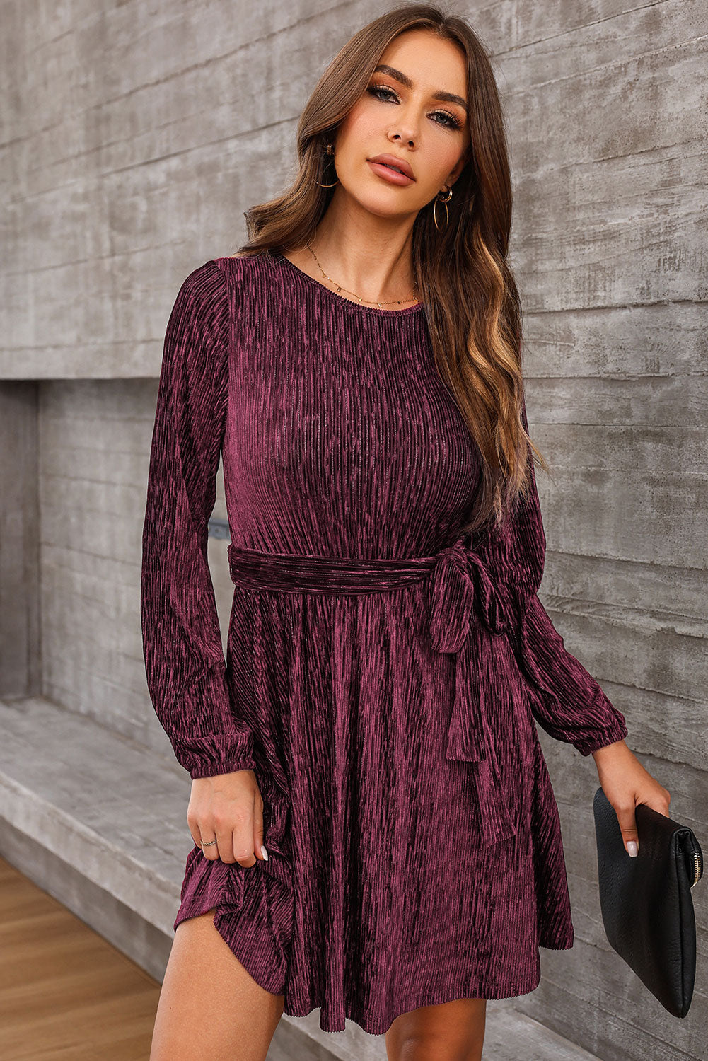 Wine textured pleated mini dress with long sleeves and a tie waist.