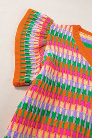 Geometric knit flutter sleeve blouse in orange with multicolor stripes and textured detail.