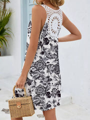 White botanical print mini dress with crochet back detail and cutout.