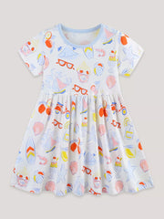 White cotton a-line toddler dress with playful summer print, short sleeves, and blue trim.