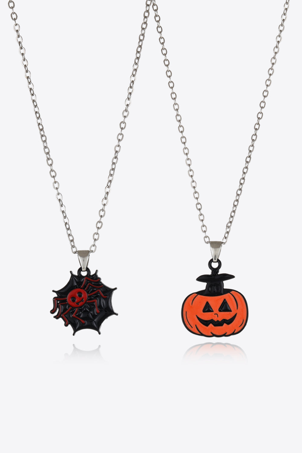 Spooky season necklaces with spiderweb and jack-o-lantern enamel pendants on silver chains.