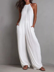 White wide-leg jumpsuit with halter neck and textured fabric.
