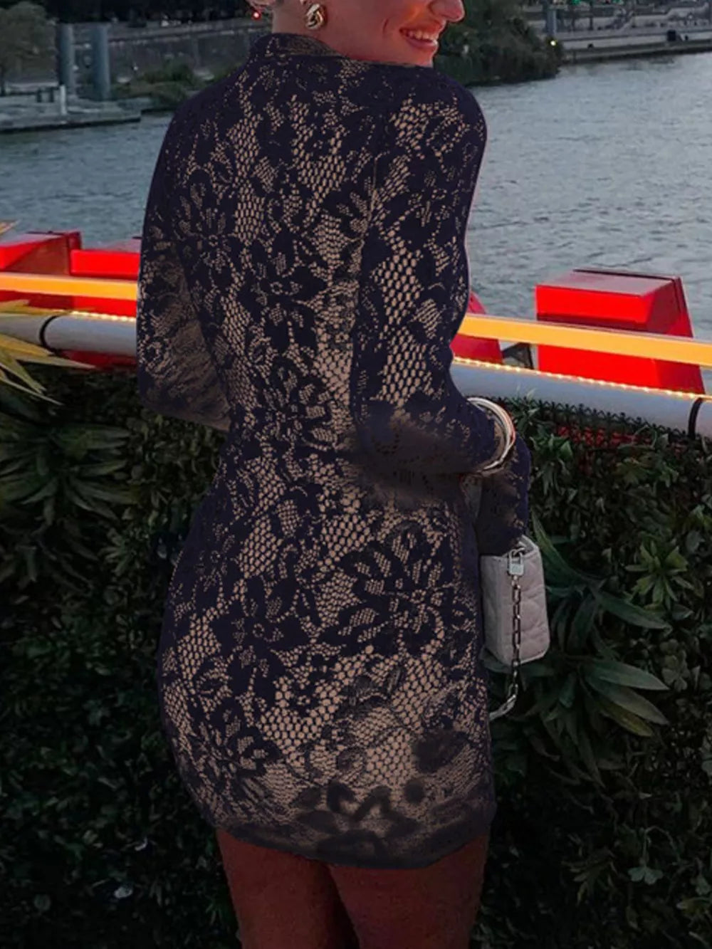 Black lace cutout mini dress with flared sleeves and a beige lining.