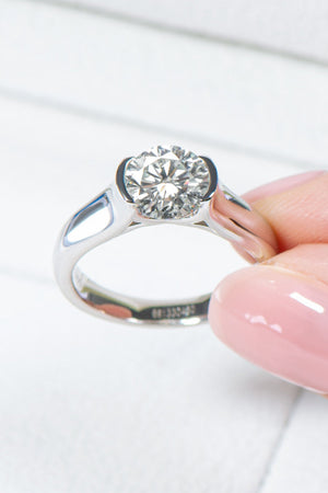 Platinum ring with a round moissanite solitaire stone in a bezel setting.