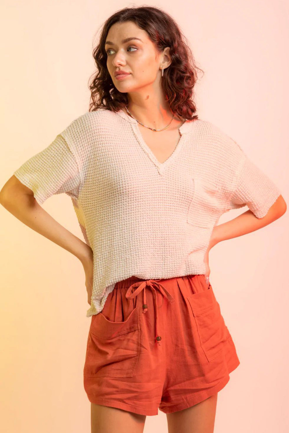 Relaxed waffle knit v-neck top in pale blush with short sleeves and a chest pocket.