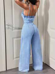 Light wash denim jumpsuit with spaghetti straps, cinched waist, and wide legs.