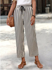 High-waisted cropped pants with black and white vertical stripes and a drawstring waist.