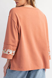 Sherbet sweatshirt with floral appliqué raglan sleeves and raw edge details.
