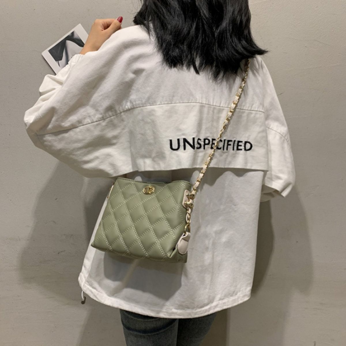 Green quilted crossbody bag with diamond pattern and chain strap