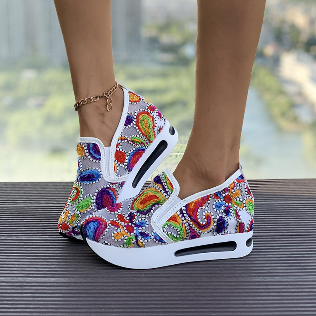 Vibrant slip-on platform sneakers with colorful paisley embroidery and white soles.