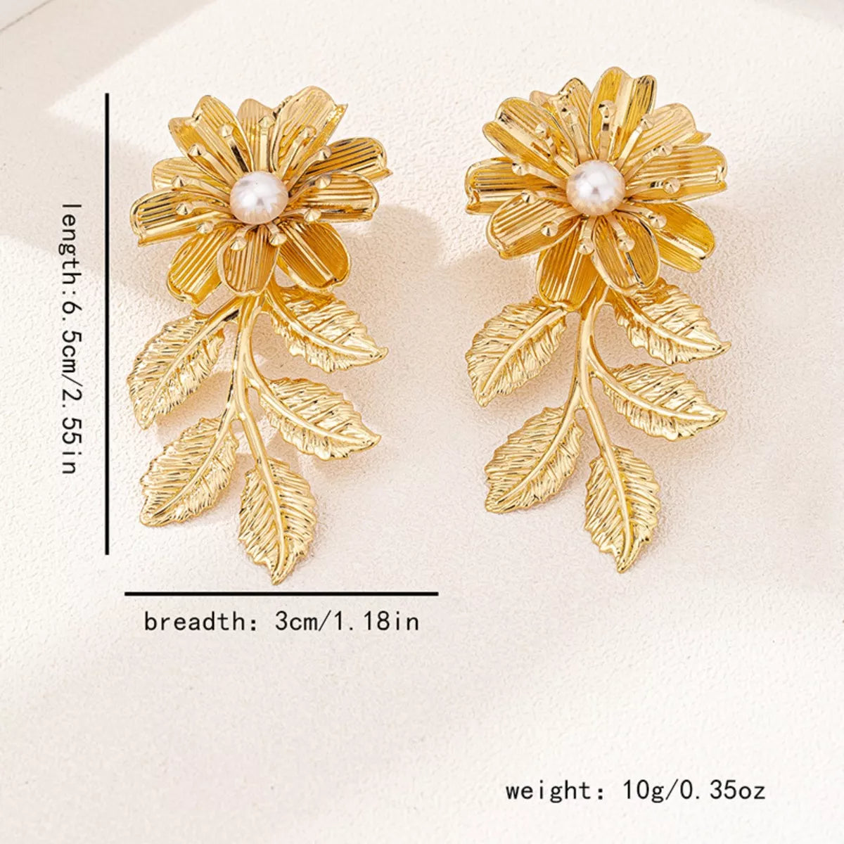 Golden floral drop earrings with pearl center and leaf accents, 18K gold-plated.