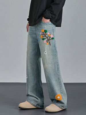 Appliquéd relaxed fit blue cotton jeans with floral embroidery detail.