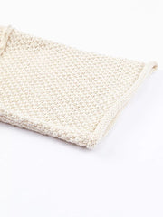 Beige knit sweater with textured weave and V-neck detail.
