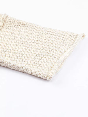 Beige knit sweater with textured weave and V-neck detail.