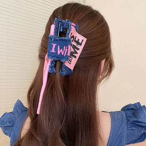Denim patchwork claw clip with pink drawcord and "I Will Be Me" text detail.