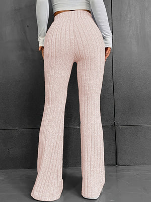 Sculpted ribbed flare trousers in blush pink polyester, featuring a high waist and bootcut leg.