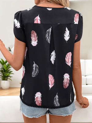 Black feather print blouse with puff sleeves and a lace hem