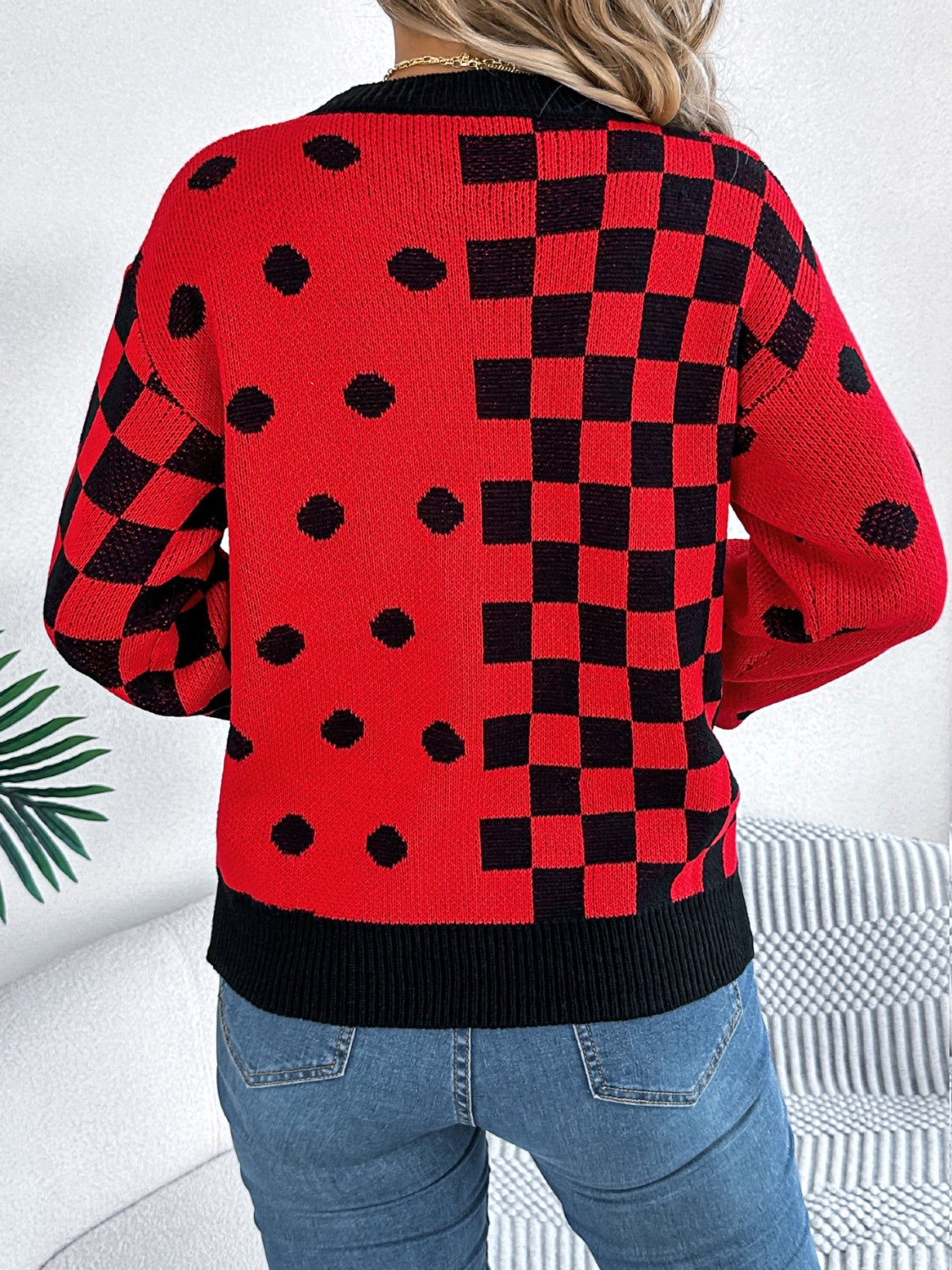 Red acrylic knit sweater with checkerboard and dot intarsia patterns.