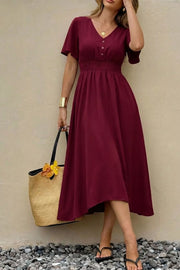 Burgundy V-neck midi dress with flutter sleeves, smocked waist, and button detail.