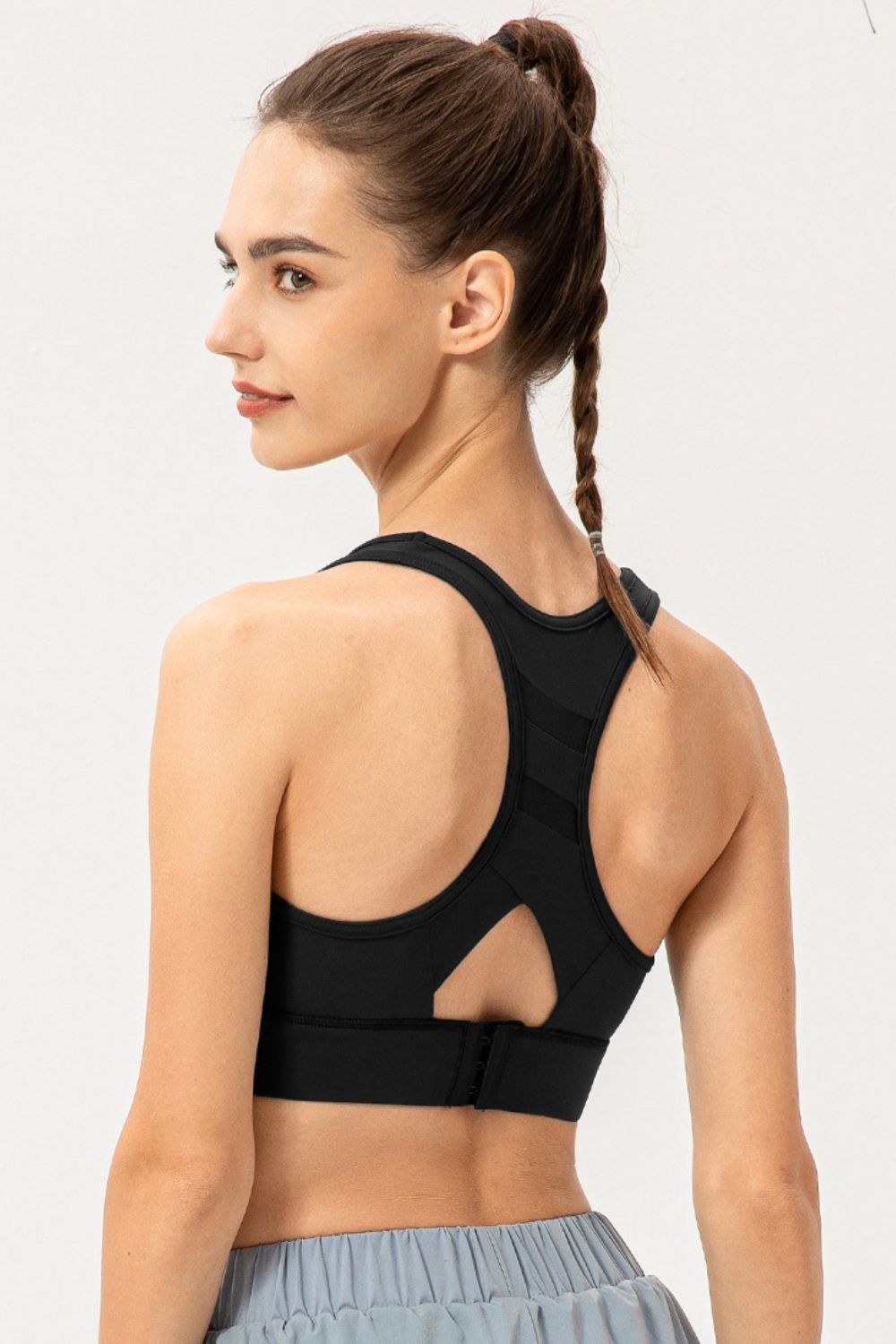 Black mesh-inset performance sports bra with racerback and cutout detail.