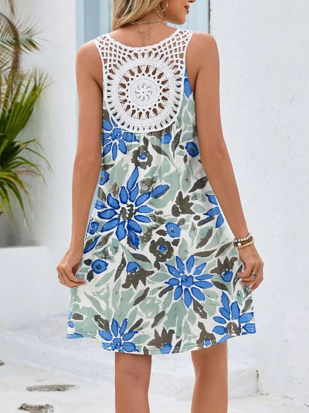 Botanical print mini dress with white crochet detail on back, blue-green flower pattern.