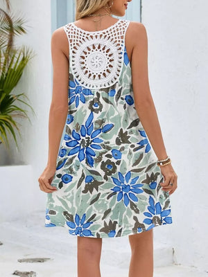 Botanical print mini dress with white crochet detail on back, blue-green flower pattern.