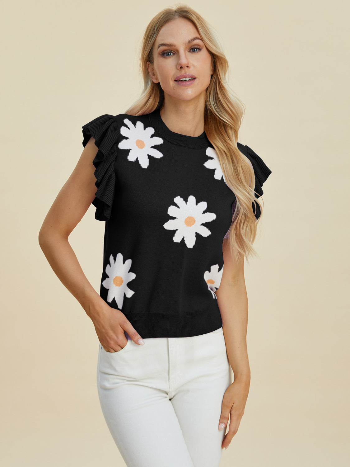 Black knit blouse with white daisy print and ruffled cap sleeves.