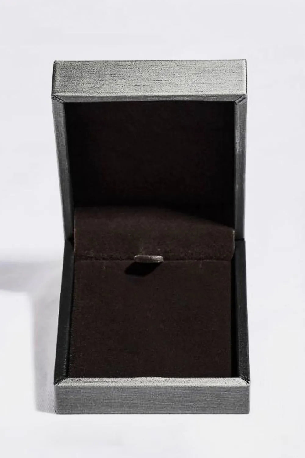 Open jewelry box with dark green velvet lining and silver textured exterior.