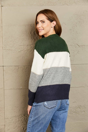 Colorblock acrylic cardigan with metallic trim in green, white, grey, and navy.