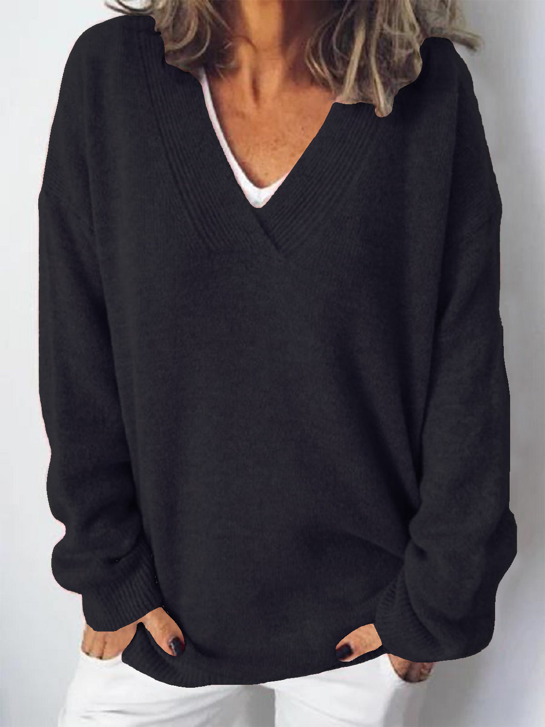 Black ribbed knit V-neck sweater with a relaxed fit, worn over a white top.